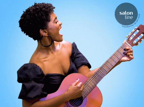 woman playing the purple guitar on orange background