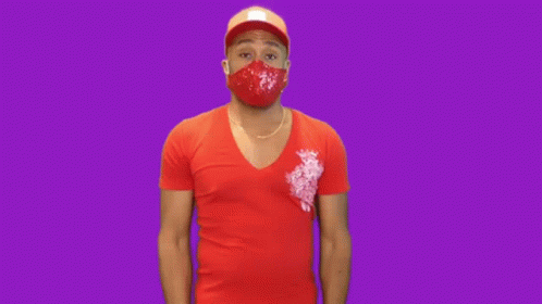 the man wearing a blue shirt with the pink mask is standing in front of a pink background