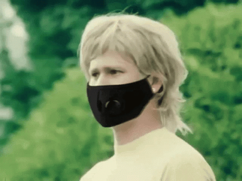 a boy with blond hair wearing a black face mask