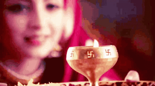 a blurry image shows a candle and a woman looking at the table