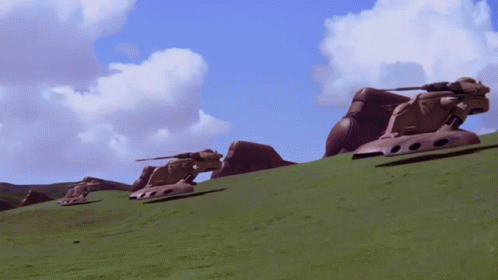 two flying vehicles sitting on top of a green hill