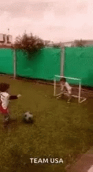 a man kicking a soccer ball across a soccer field