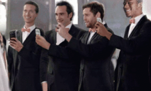 a group of men standing next to each other holding smart phones