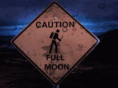 a sign that says caution full moon next to a picture of a person walking