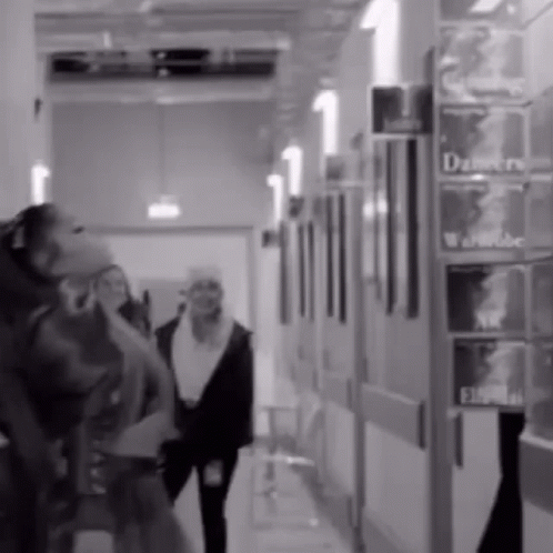 two woman talking on the phone while walking down a hallway