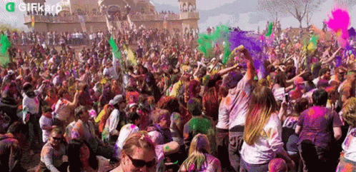 people covered in blue, green and purple paint at an outdoor festival