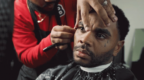 a man getting a haircut by a hair stylist