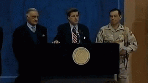 five men standing behind a podium talking