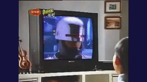 a boy is watching television with a weird mask on