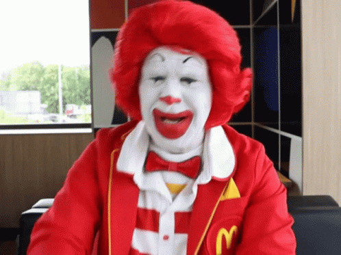 a person in a clown outfit sitting at a desk