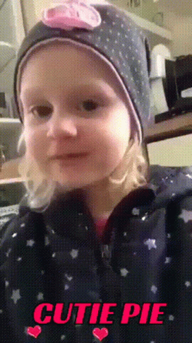 little girl wearing a hat with a bow on top of her head