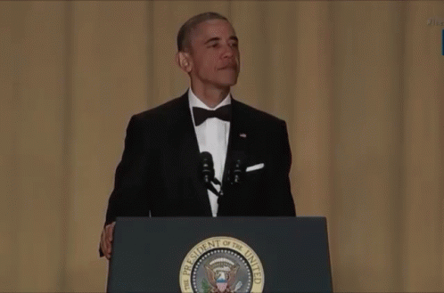 a man in a tuxedo at a podium