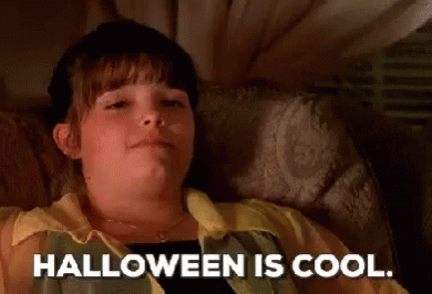 a child lying in a bed with the words halloween is cool written below