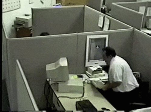 a person is working at their cubicles with computer and printer