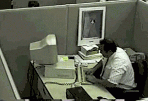 man working in the office and looking through his computer screen