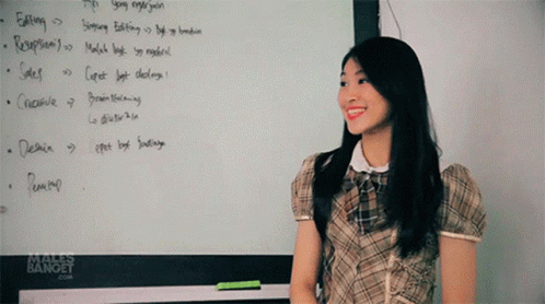 the girl is standing up in front of a whiteboard