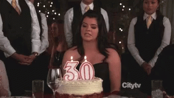 a woman is looking at a birthday cake