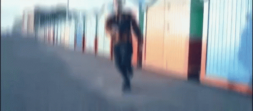 this blurry image shows a woman walking down a sidewalk