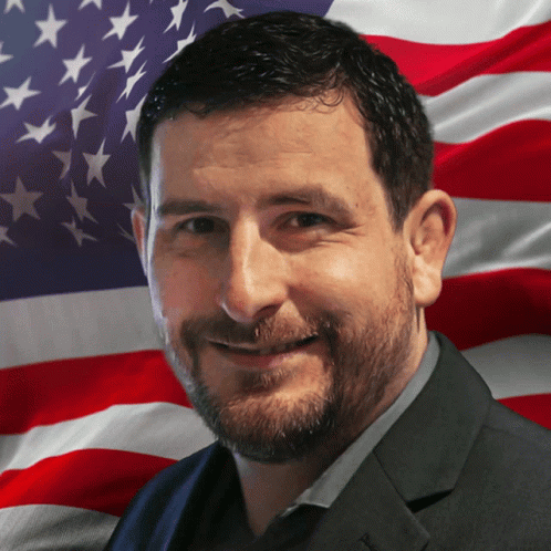 a man is smiling against a blue american flag