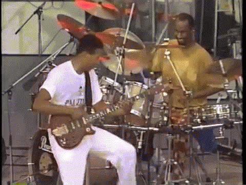 a couple of men playing guitars and drums