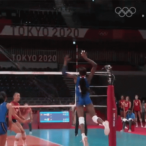 two men are playing volleyball and jump for the ball