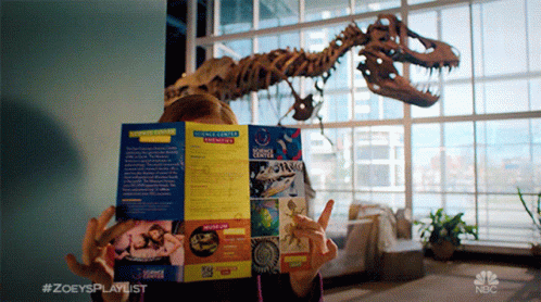 a model dinosaur inside a building with a large window
