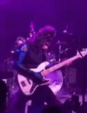 a person with a guitar and purple light
