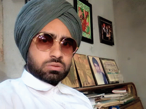 man with round sunglasses and turban in home office