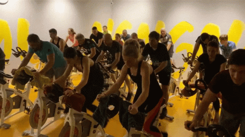 a bunch of people riding exercise bikes on their legs