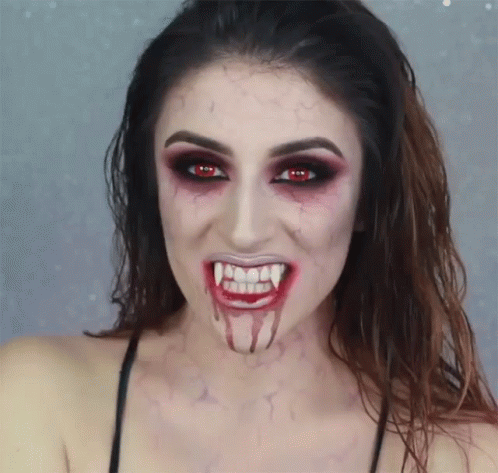a woman with makeup and painted teeth posing for the camera