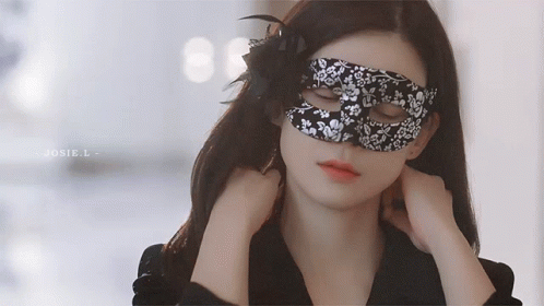 a woman wearing an eye mask and a dark jacket