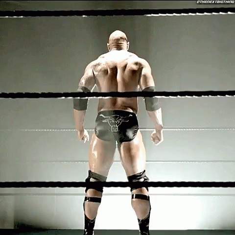 wrestler standing in ring while wearing knee pads