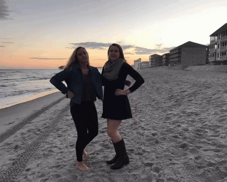 two woman standing next to each other on a beach