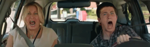 two people sitting in a car talking with each other