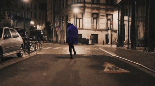 man walking down the street at night in the city