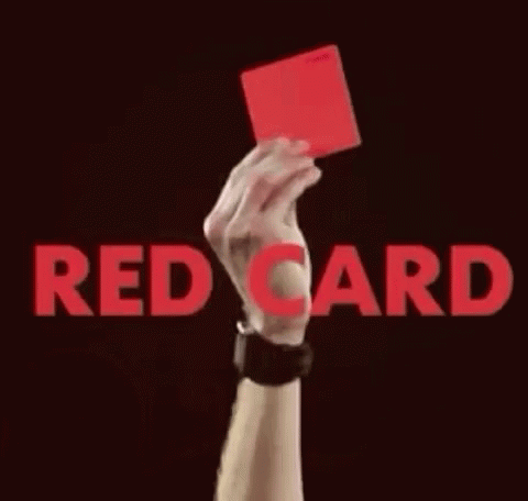 someone holding up a red card, against a dark background