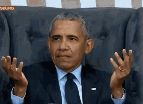 president obama gesturing while sitting in a brown chair