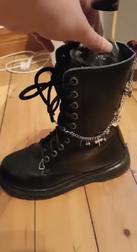 a pair of black boots with chains around them on a wooden floor
