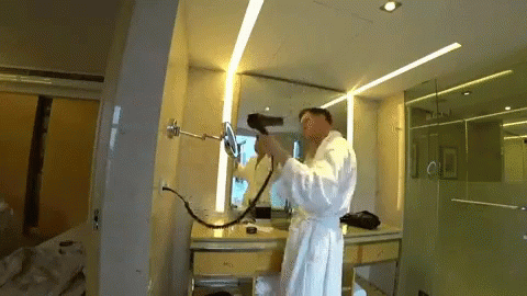 a person in white clothing spray painting in a room