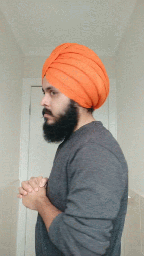 a man wearing a turban standing in front of a mirror