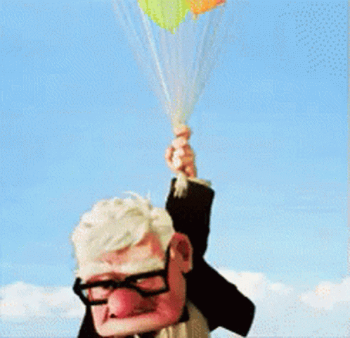 a guy with glasses holds some balloons with a string around it
