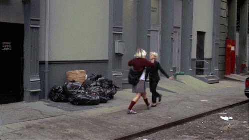 two people in costume walking past trash bags on a street