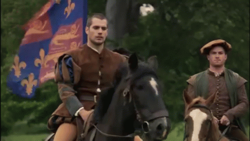 a man in military attire riding a horse next to another man in military clothing