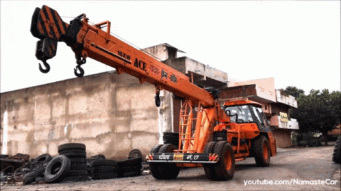 a blue crane is being used to pick up tires