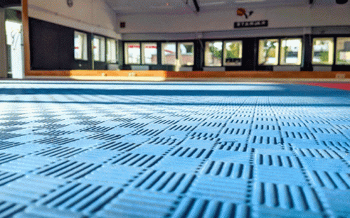 an empty gym floor is covered with yellow floor tiles