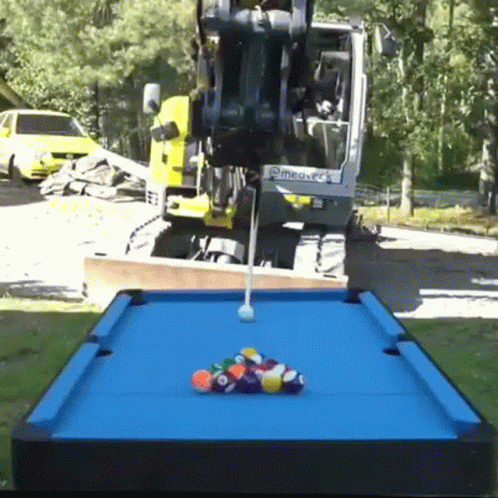 a pool table in the park has balls laying on it