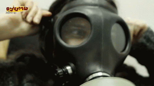 a man wearing a gas mask with blue gloves