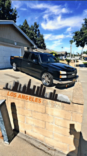 an artistic view of the side of a wall showing a truck coming down and over the edge of it, as a cityscape