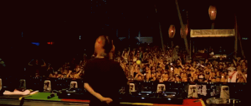 a dj and his turntables on stage as people watch