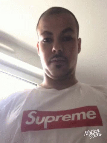 man with white shirt that says supreme, while he looks like a person with blue eyes
